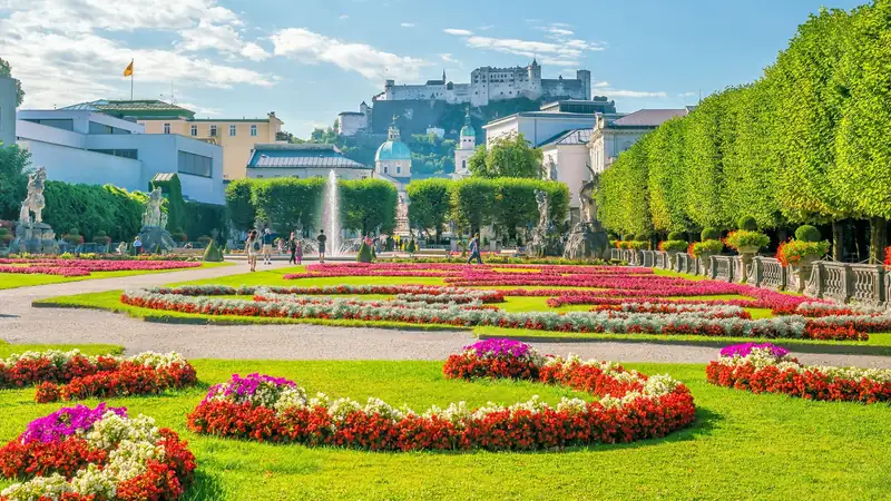 Flowerbeds and fountains at Mirabell Gardens, with Salzburg Cathedral and Hohensalzburg Fortress beyond